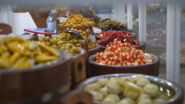 Selection of middle eastern pickled food displayed in bins on a fresh food market