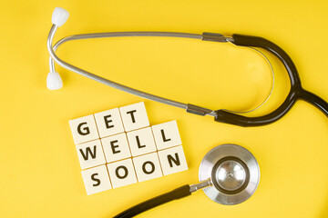 Medical concept. Layout of alphabet blocks and a stethoscope with text Get Well Soon. Selective...