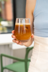 Female hand holding cold espresso tonic, summer drink