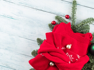 Traditional red ugly christmas new year winter sweater with green ornament on white wooden table