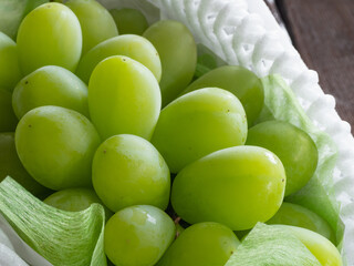 クッション材に包まれた贈答品のシャインマスカットのクローズアップ。