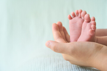 Obraz na płótnie Canvas Newborn baby feet in mother's hands