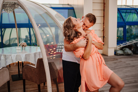a man and a woman in love dance to a rooftop cafe on a date.