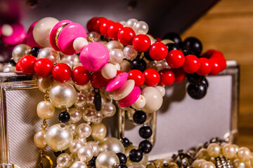 Aluminium case full of different jewelry on wooden table