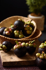 Mangosteen fruit on black background, tropical fruit mostly in Southeast Asia, refreshing and healthy eating sweet taste