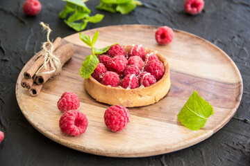 Fototapeta na wymiar A healthy tasty dessert of cheese raspberry tart. Creative atmospheric decoration