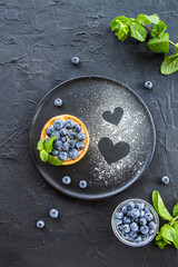 Obraz na płótnie Canvas A healthy tasty dessert of cheese blueberry tart. Creative atmospheric decoration