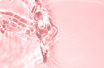 Blurred or defocused transparent clear water waves in sunlight.  Pink liquid colored clear water...