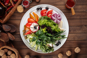 Fresh vegetables platter with greens on decorated background
