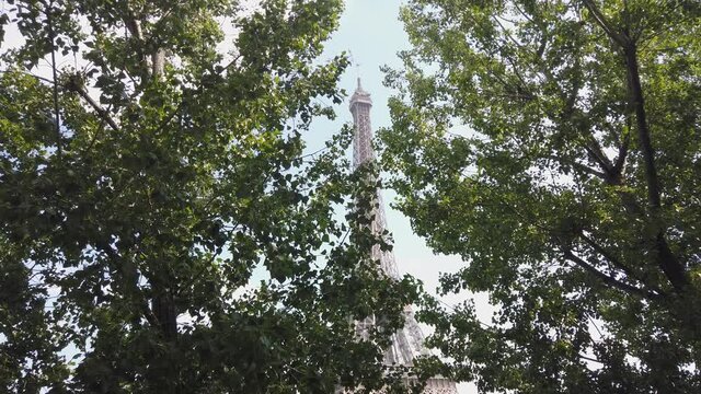 Shot Of Eiffel Tower through Trees During The Day With Blue Sky After Covid Situation, Paris France
