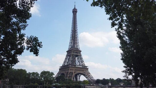 Shot Of Eiffel Tower through The Trees During The Day With Blue Sky, Paris France
