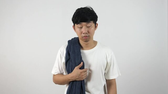 Asian man with towel wake up at morning feeling sleepy and yawn on white isolated background,Lazy man concept