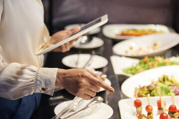 Fototapeta na wymiar Hands of female restaurant owner checking plates with food ready for serving