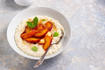 oatmeal porridge with peaches. the concept of breakfast, proper nutrition, healthy nutrition, dairy products, home food, summer food

