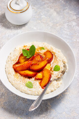 oatmeal porridge with peaches. the concept of breakfast, proper nutrition, healthy nutrition, dairy products, home food, summer food

