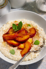 oatmeal porridge with peaches. the concept of breakfast, proper nutrition, healthy nutrition, dairy products, home food, summer food

