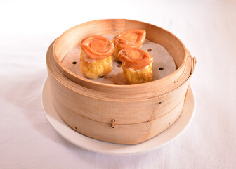 Hong Kong steamed siew mai meatball dumpling with wanton skin abalone and roe in bamboo basket asian dim sum menu