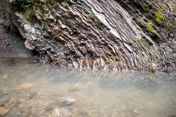 Sheer rocky bank of the Prut Carpathian mountain river