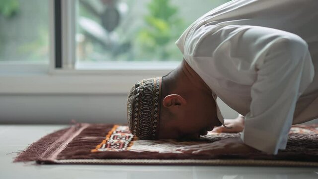 A middle-aged Asian Muslim man prays at his home during the month of Ramadan, 4k resolution.