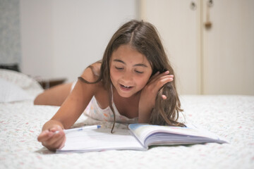 Happy young girl making holiday school homework. - obrazy, fototapety, plakaty