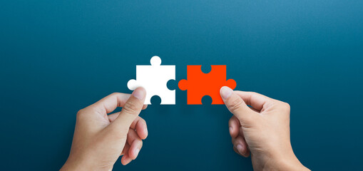 Businessman hands connecting puzzle pieces representing the merging of two companies or joint venture, partnership, Mergers and acquisition concept - obrazy, fototapety, plakaty