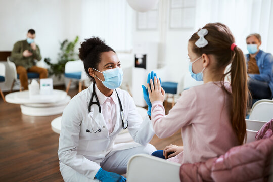 Happy Black Dentist And Small Girl Greeting And Giving High-five To Each Other In Waiting Room At Dental Clinic.