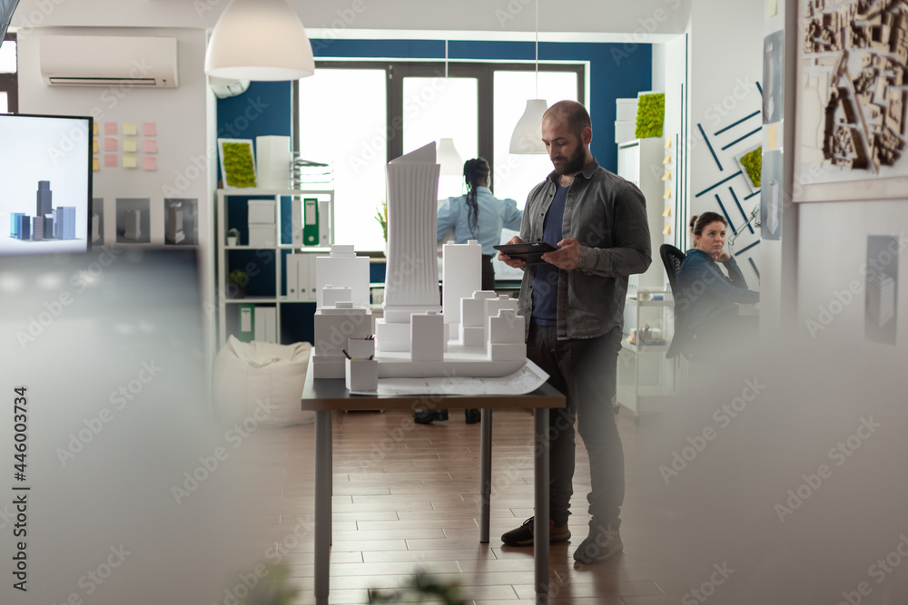 Poster architecture businessman working on tablet at office for designing building model maquette. young bu