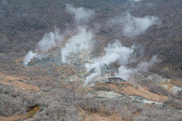 Fototapeta na wymiar Small house set up on mount in Kami Mountain with smoky surrounding area,Owakudani Hell Valley Hakone Boiling steam ,Japan