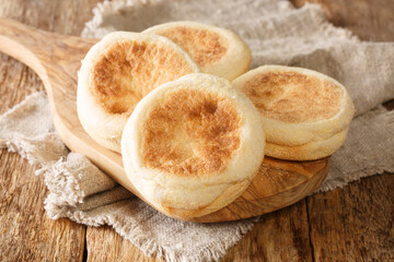 For a delicious breakfast, English muffins buns close-up on a wooden board on the table. horizontal