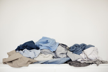 pile of dirty laundry over white wall background with copy space