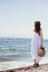 Fototapeta na wymiar 浜辺で遠くを見つめる女性（暖色シャドウ）