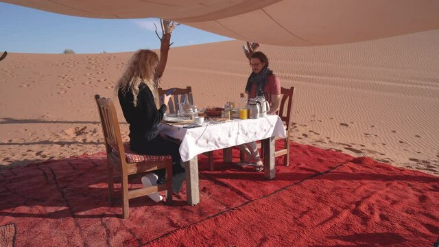 An Influencer Couple Take Photo of their Food while Staying at a Luxury Desert Camp - static shot