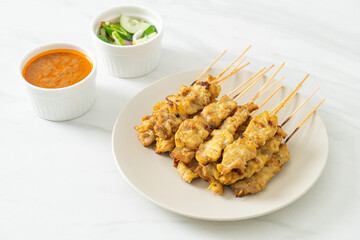 Pork satay with peanut sauce pickles which are cucumber slices and onions in vinegar