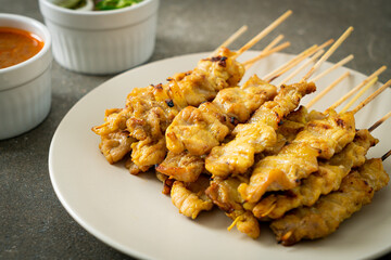 Pork satay with peanut sauce pickles which are cucumber slices and onions in vinegar