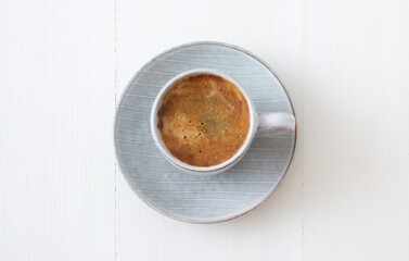 Cup of coffe on white wooden table. Flat lay, top down view.