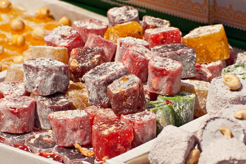 Turkish national sweets are sold at the fair. Multi-colored Asian desserts stacked on the table. Rahat lokum in bulk is sold at the festival.