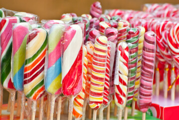 Fototapeta na wymiar Many colorful lollipops on a stick. Sweets are sold at the city fair.