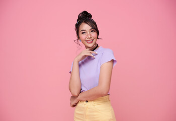 Happy pretty Asian teenage girl isolated on pink background.