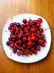 Fresh cherries with water droplets on a plate