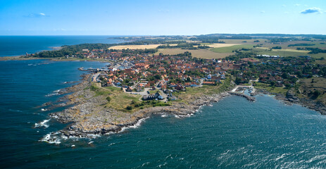 Die dänische Stadt Svaneke auf der Ostsee-Insel Bornholm vor der Granitküste von oben - obrazy, fototapety, plakaty