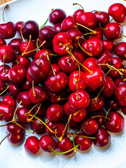 Obraz na płótnie Canvas Fresh cherries with water droplets on a plate
