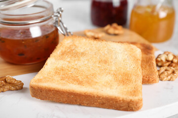 Toasts, sea buckthorn jam and walnuts for breakfast on table, closeup