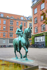 Naklejka premium Equestrian statue or monument in bronze, Aalborg, Denmark. Surrounded by historic buildings, in the city centre of Aalborg.
