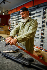 Man reload handgun at the counter in gun store