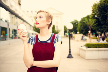 short haired woman outdoors fashion posing glass with drink