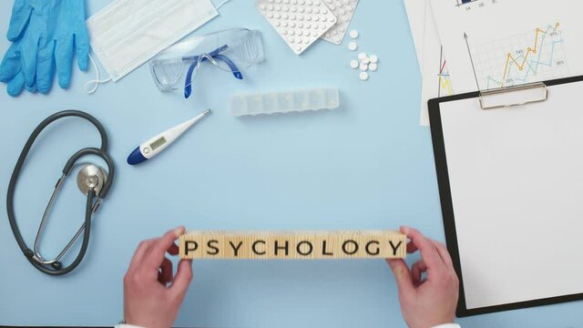 On medical table is composed the word psychology of wooden cubes with letters, the view from above. Concept of mental and psychical health.