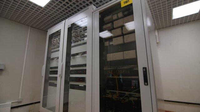 Large metal cabinet with modern switch gear and glass doors in electricity production substation control office premise