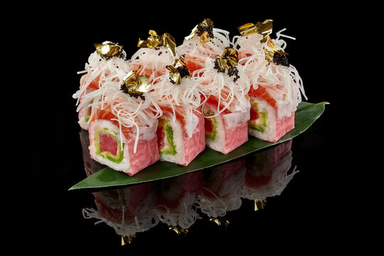 Sushi rolls with salmon and tuna in mamenori with daikon, tobiko and edible gold