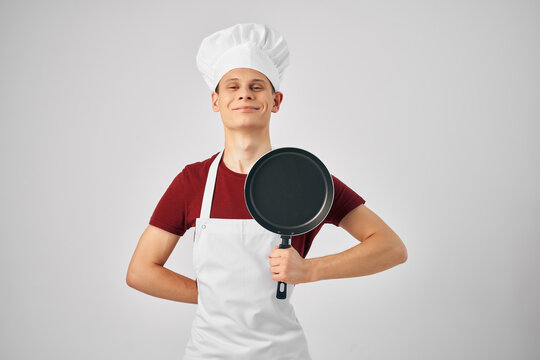 man chef hugging frying pan cooking light background - Powered by Adobe
