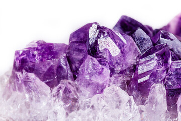 Macro mineral stone purple amethyst in crystals on a white background